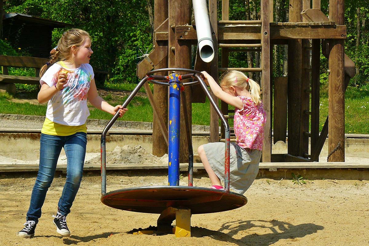 2 Kinder spielen auf dem Spielplatz