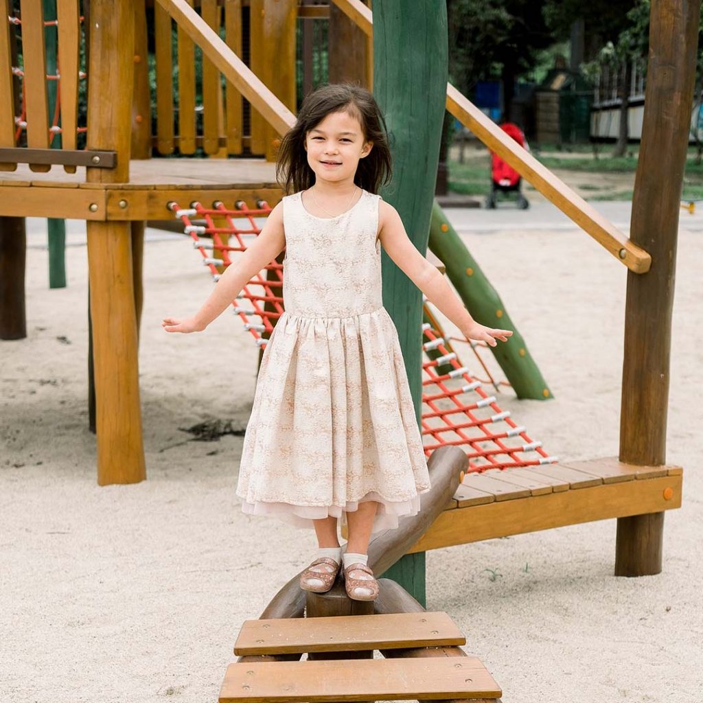 Mädchen im Kleid auf dem Spielplatz