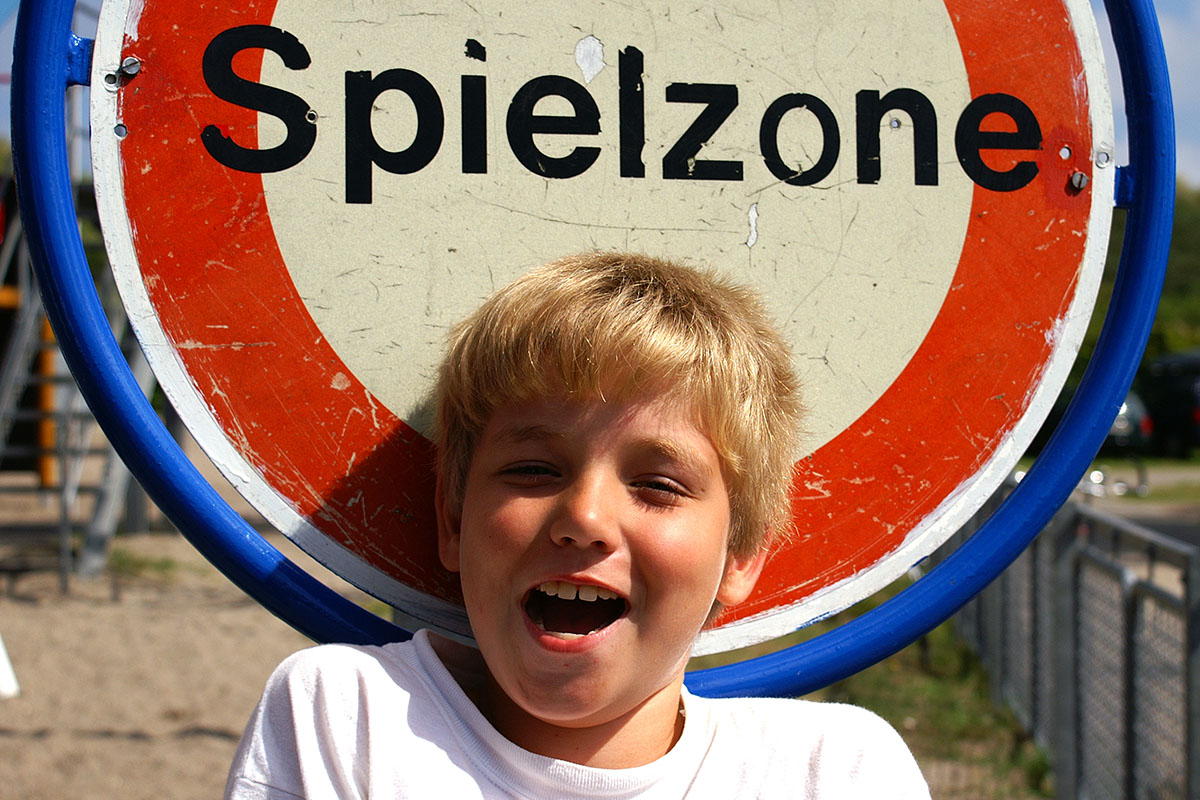 Kind vor einem Verbotsschild Aufschrift Spielzone