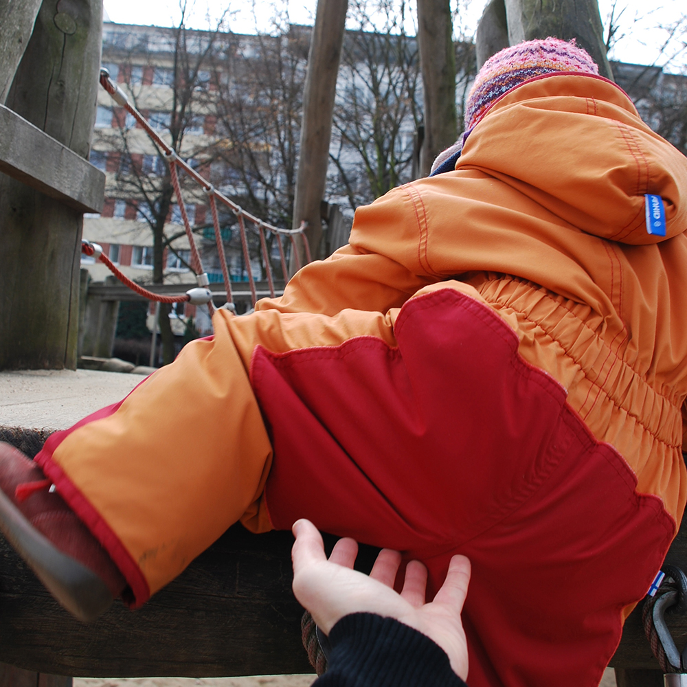 Kind klettert auf ein Klettergerät