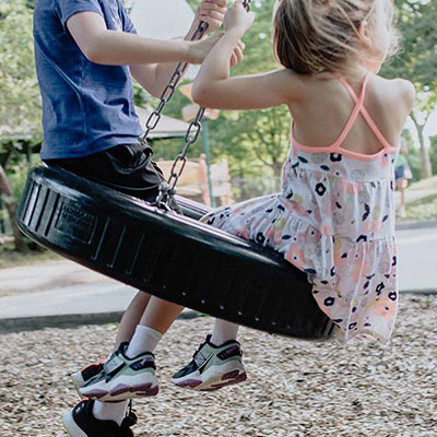 Kinder schaukeln auf einer Reifenschaukel