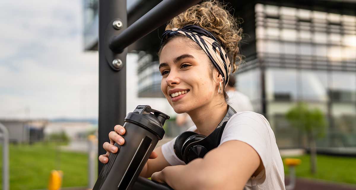 FITNESS-TRAINING AUF DEM SPIELPLATZ WÄHREND DIE KINDER TOBEN