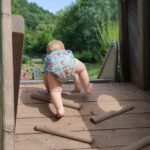 Kleinkind klettert auf dem Spielplatz