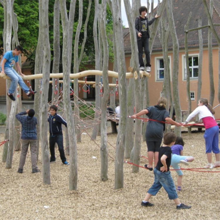 Kinder klettern auf einem hohen Klettergerät aus Holzstangen