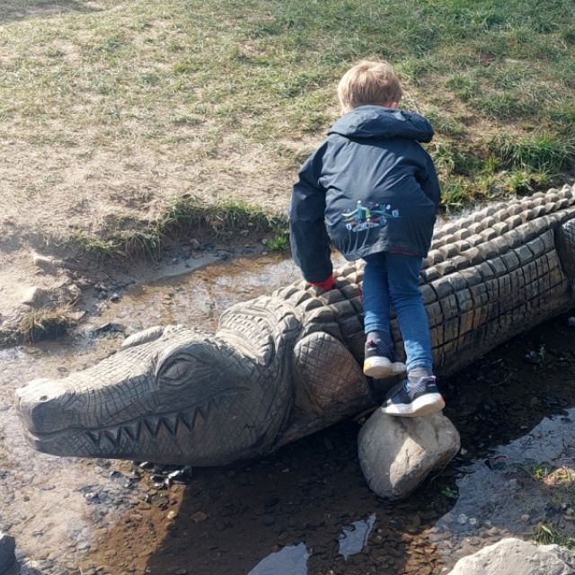 Kind klettert auf ein Stielplatzgerät in Krokodilfarm