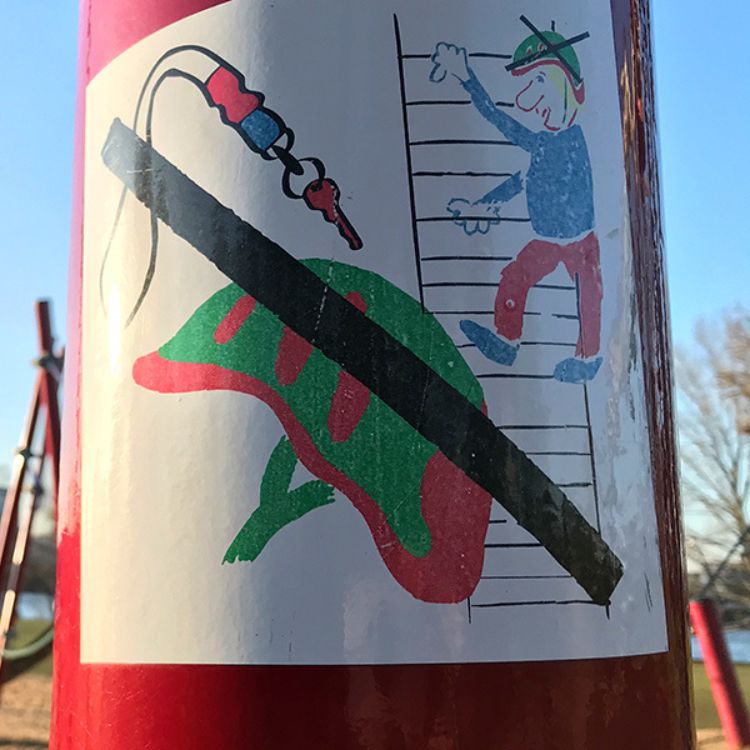 "Helm ab!" Hinweis-Pictogramm an einem Klettergerät